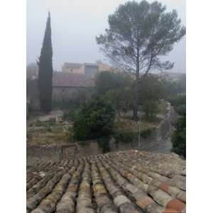 Fog Drifts Between Buildings in the Walled Village of Aspiran, France 