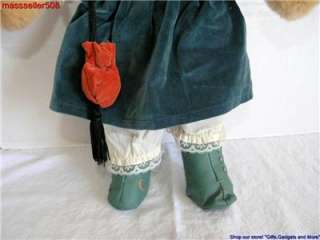 SHE IS WEARING A DRESS, JACKET WITH ATTACHED PURSE, BLOOMERS, ATTACHED 