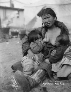 Description 1904 photo Inuit Eskimo woman breast feeding two babies 